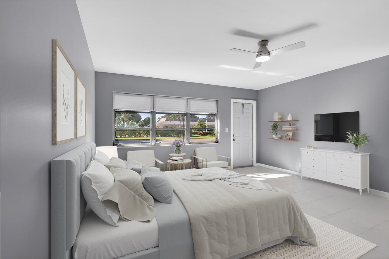 14280 Nesting Way, Unit B Delray Beach, FL 33484 - Photo 6 of 43 a large bedroom with a large bed and a flat screen tv