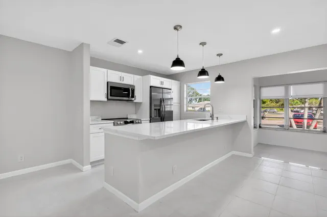 a large white kitchen with a large window