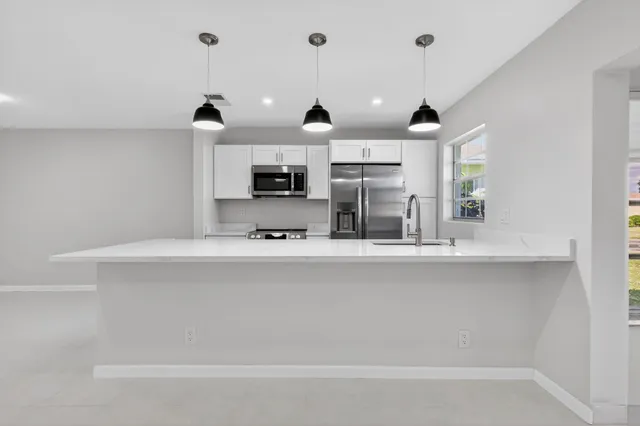 a view of kitchen with sink and microwave