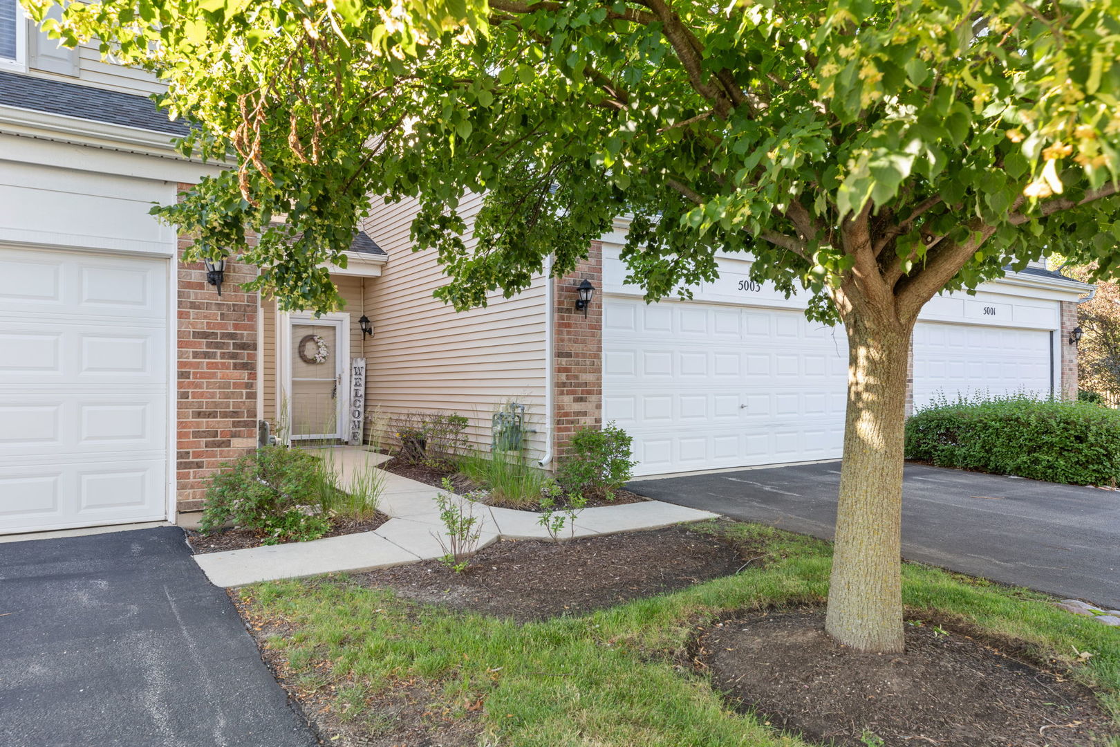 5003 Syracuse Court Plainfield, IL 60586 - Photo 2 of 18 a front view of a house with garden