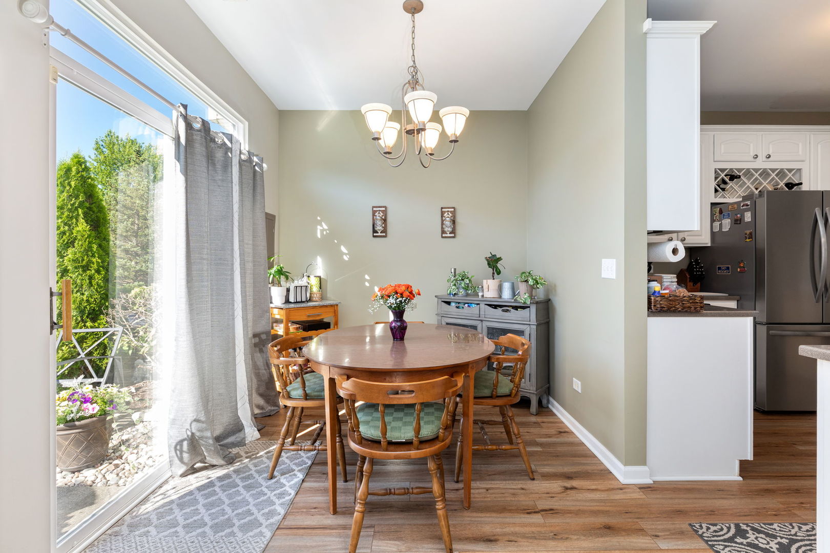 5003 Syracuse Court Plainfield, IL 60586 - Photo 7 of 18 a dining room with furniture a chandelier and wooden floor