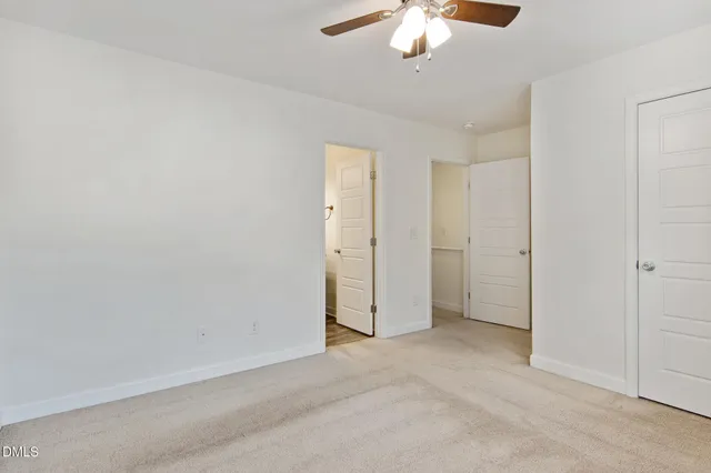 an empty room with a chandelier fan