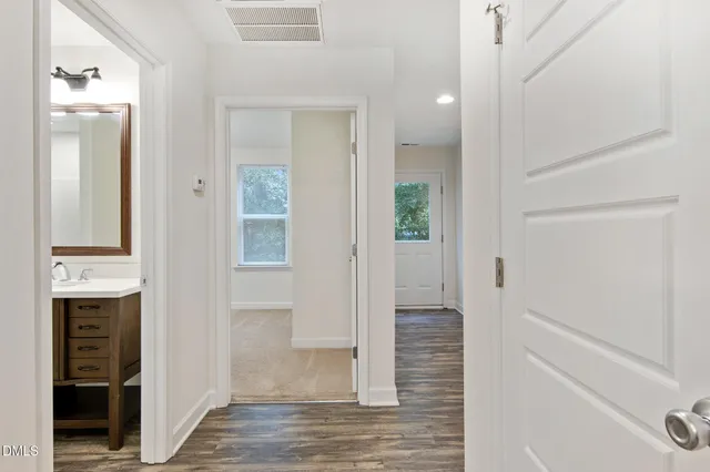 a view of a hallway with wooden floor and staircase