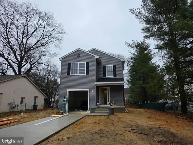 a front view of a house with a yard and trees