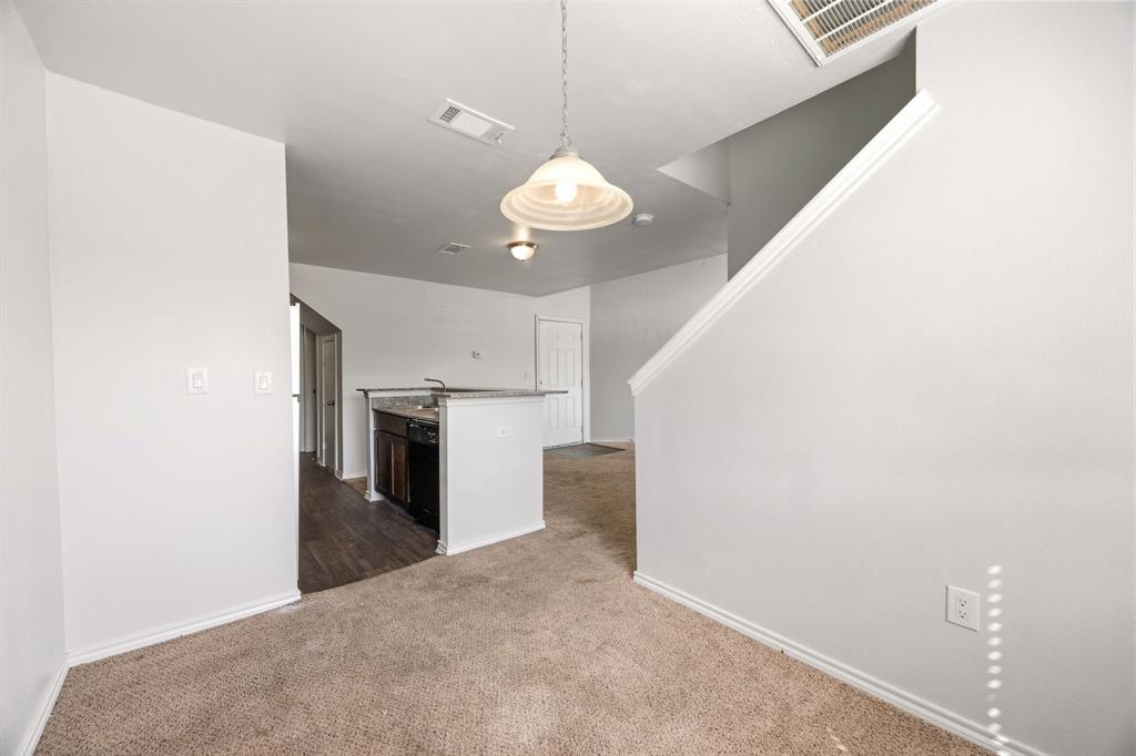 9837 Walnut Street, Unit S203 Dallas, TX 75243 - Photo 10 of 26 The property features a kitchen area with a dark countertop and a sink, visible from a carpeted living space