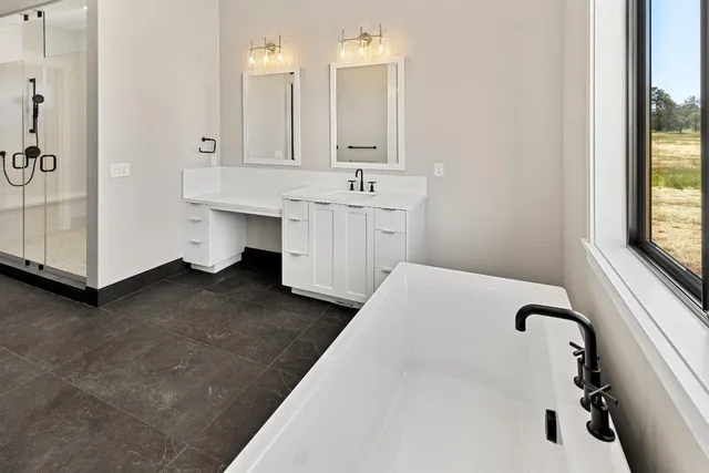 a spacious bathroom with a double vanity sink a mirror and a bathtub
