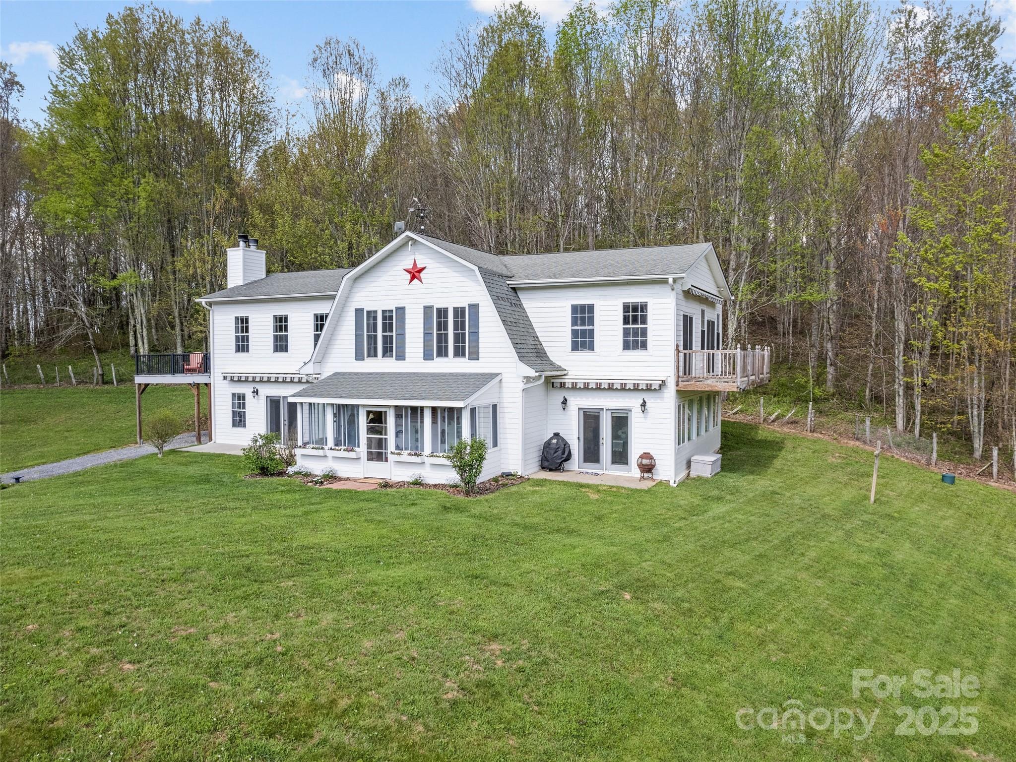 6780 Max Patch Road Clyde, NC 28721 - Photo 4 of 32 a big white house with a big yard and large trees
