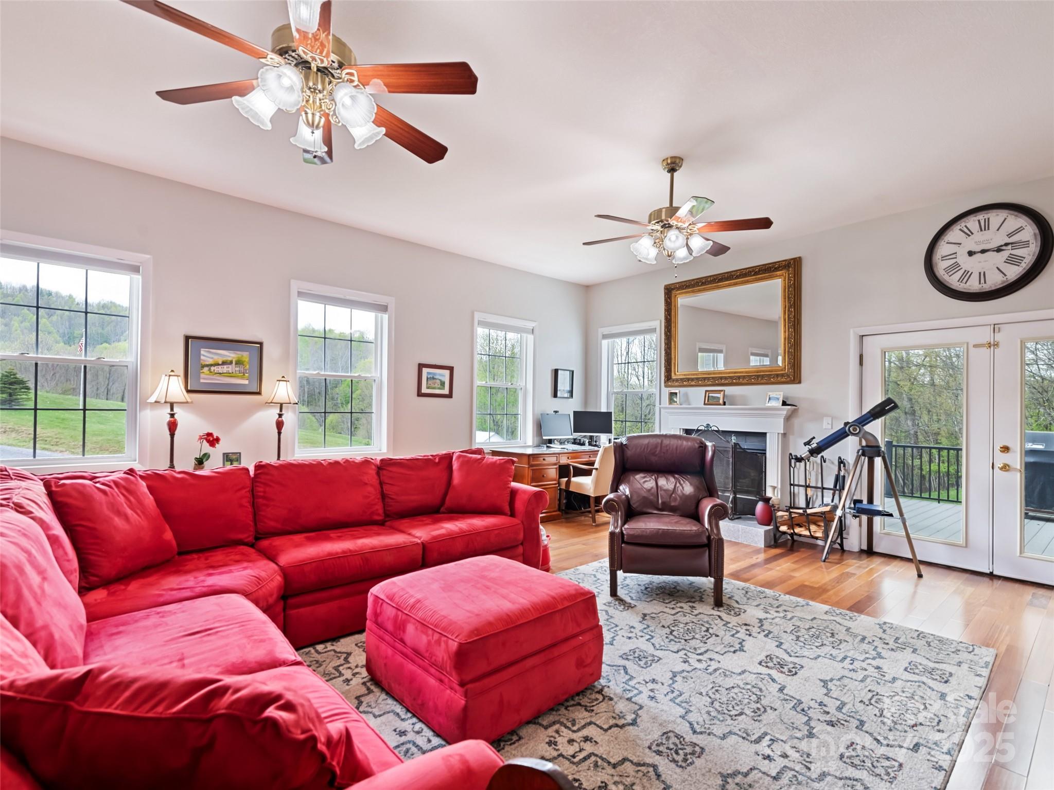 6780 Max Patch Road Clyde, NC 28721 - Photo 9 of 32 a living room with furniture a fireplace and a chandelier