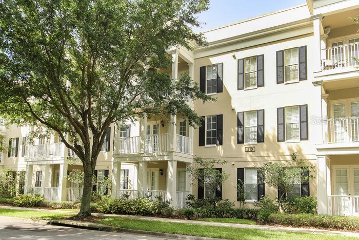 910 Spring Park Street, Unit 202 Celebration, FL 34747 - Photo 1 of 1 a front view of a residential apartment building with a yard