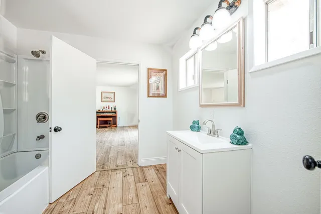 a bathroom with a sink a mirror and a shower