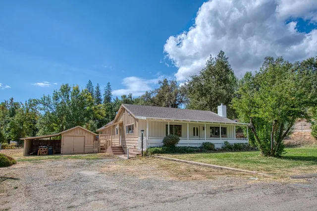 a front view of a house with a yard and trees