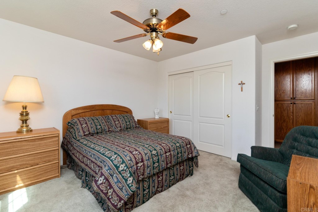 575 Rancho Trail Ramona, CA 92065 - Photo 15 of 47 a bedroom with a bed and ceiling fan
