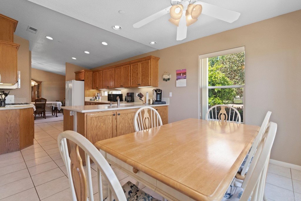 575 Rancho Trail Ramona, CA 92065 - Photo 21 of 47 a kitchen with stainless steel appliances granite countertop a stove a refrigerator a kitchen island a table and chairs