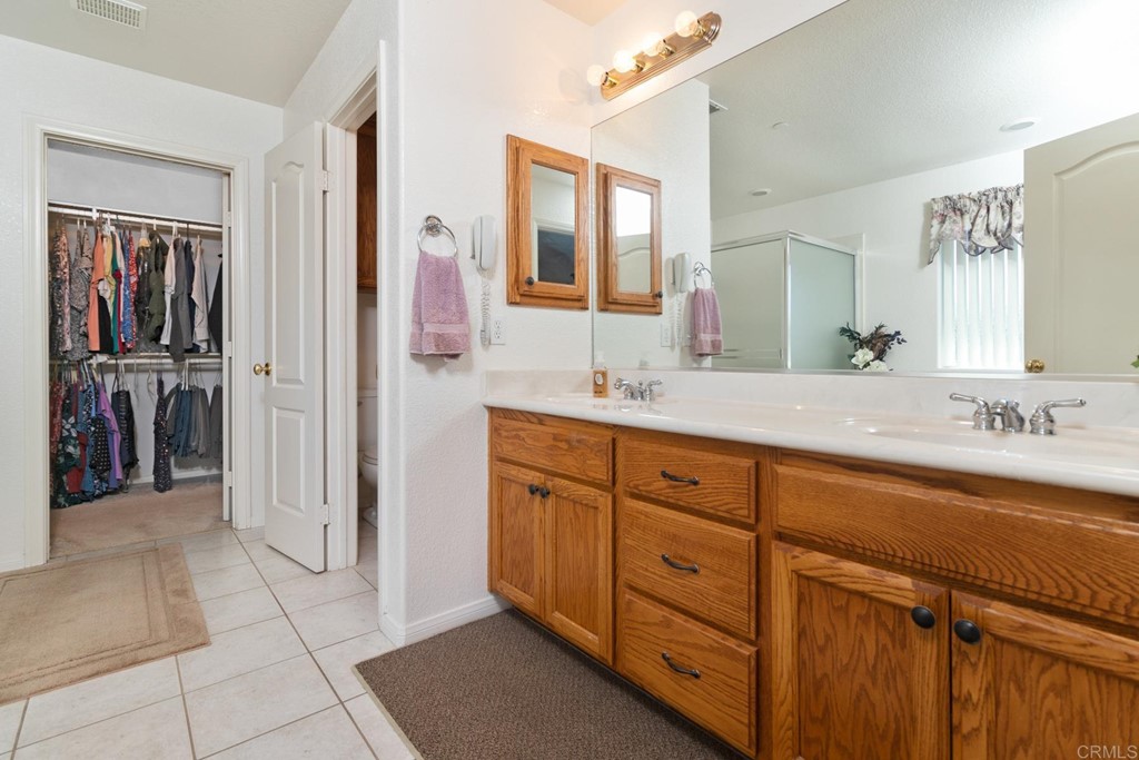 575 Rancho Trail Ramona, CA 92065 - Photo 32 of 47 a spacious bathroom with a double vanity sink a mirror and a shower