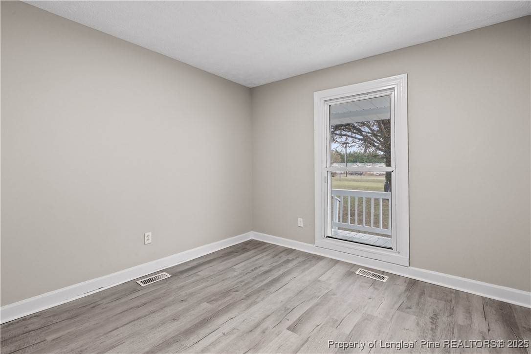 2302 Odom Road Hope Mills, NC 28348 - Photo 18 of 33 an empty room with wooden floor and windows