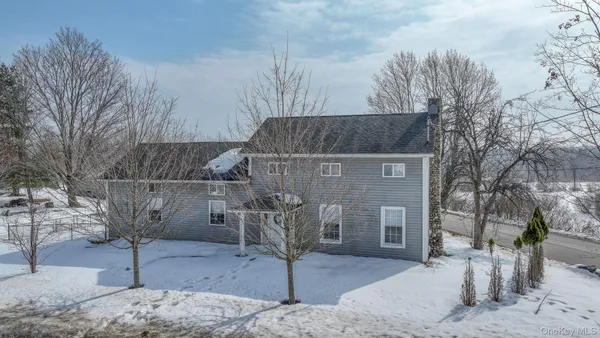 a front view of a house with a yard covered in snow