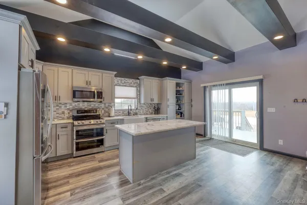 a large white kitchen with kitchen island a stove a sink and a refrigerator