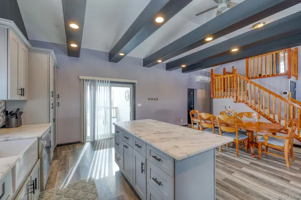 a bathroom with a granite countertop sink a dining table and chairs