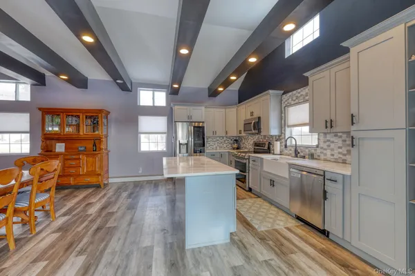 a large kitchen with stainless steel appliances granite countertop a lot of counter space and a wooden floors