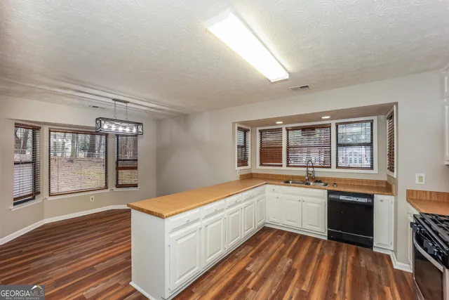 a large white kitchen with sink and cabinets