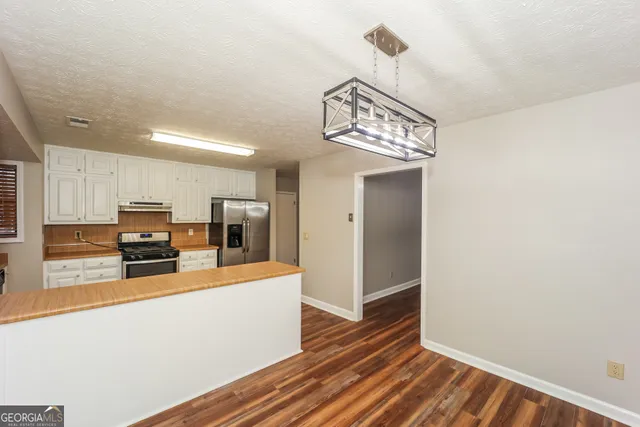 a view of a kitchen with a sink and wooden floor
