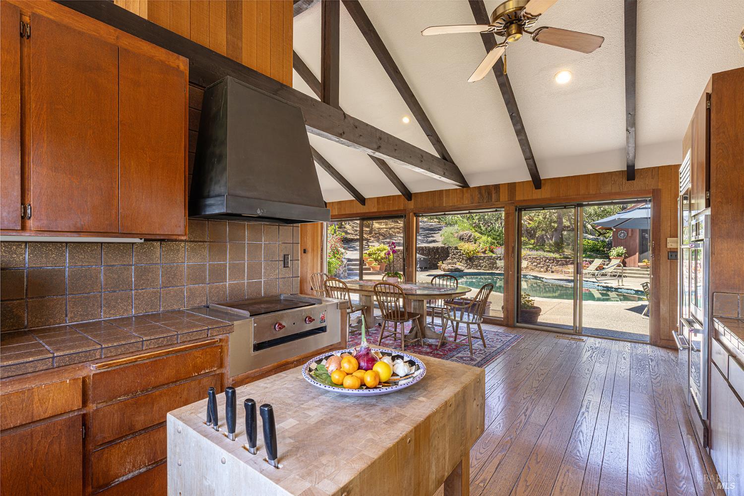 2231 First Avenue Napa, CA 94558 - Photo 15 of 64 a kitchen with stainless steel appliances granite countertop a sink a stove top oven a dining table and chairs with wooden floor