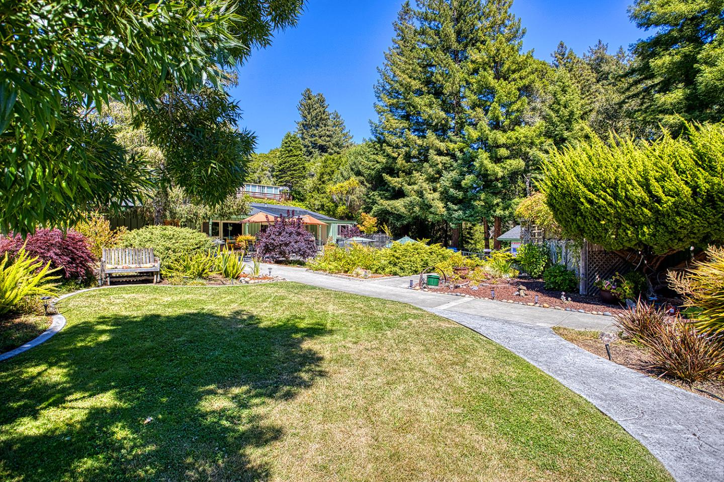 7 Oak Shadows Lane Aptos, CA 95003 - Photo 25 of 36 a backyard of a house with table and chairs plants and large trees