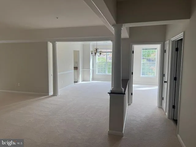 a view of a big room with windows and chandelier fan