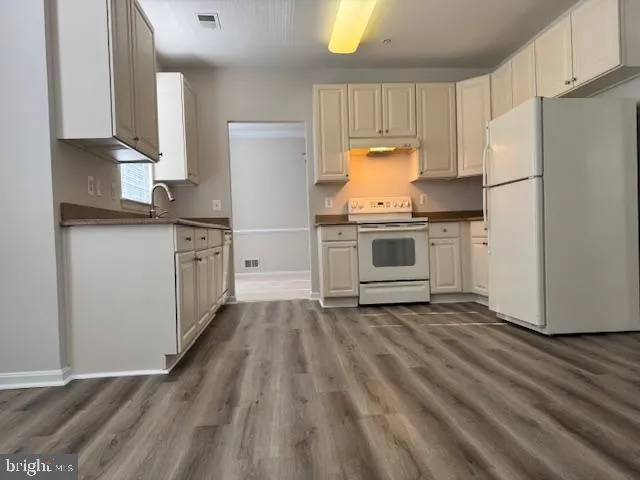 a kitchen with white cabinets and white appliances