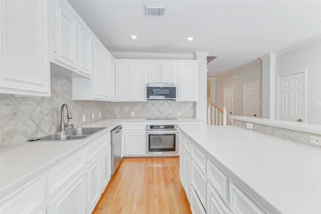 a kitchen with stainless steel appliances granite countertop white cabinets sink and granite counter tops