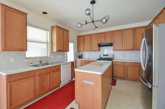 a kitchen with a sink stove and refrigerator