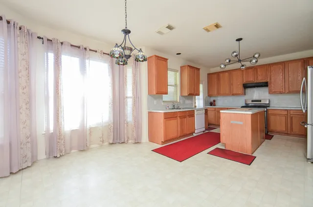 a kitchen with kitchen island a stove a sink and a refrigerator
