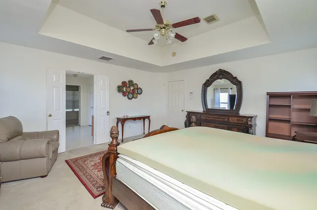 a bedroom with a large bed and a chandelier