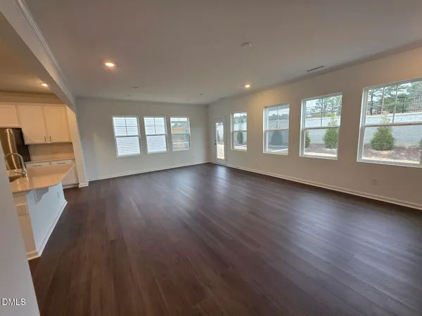 a kitchen with stainless steel appliances a microwave a sink a stove a refrigerator cabinets and a wooden floor