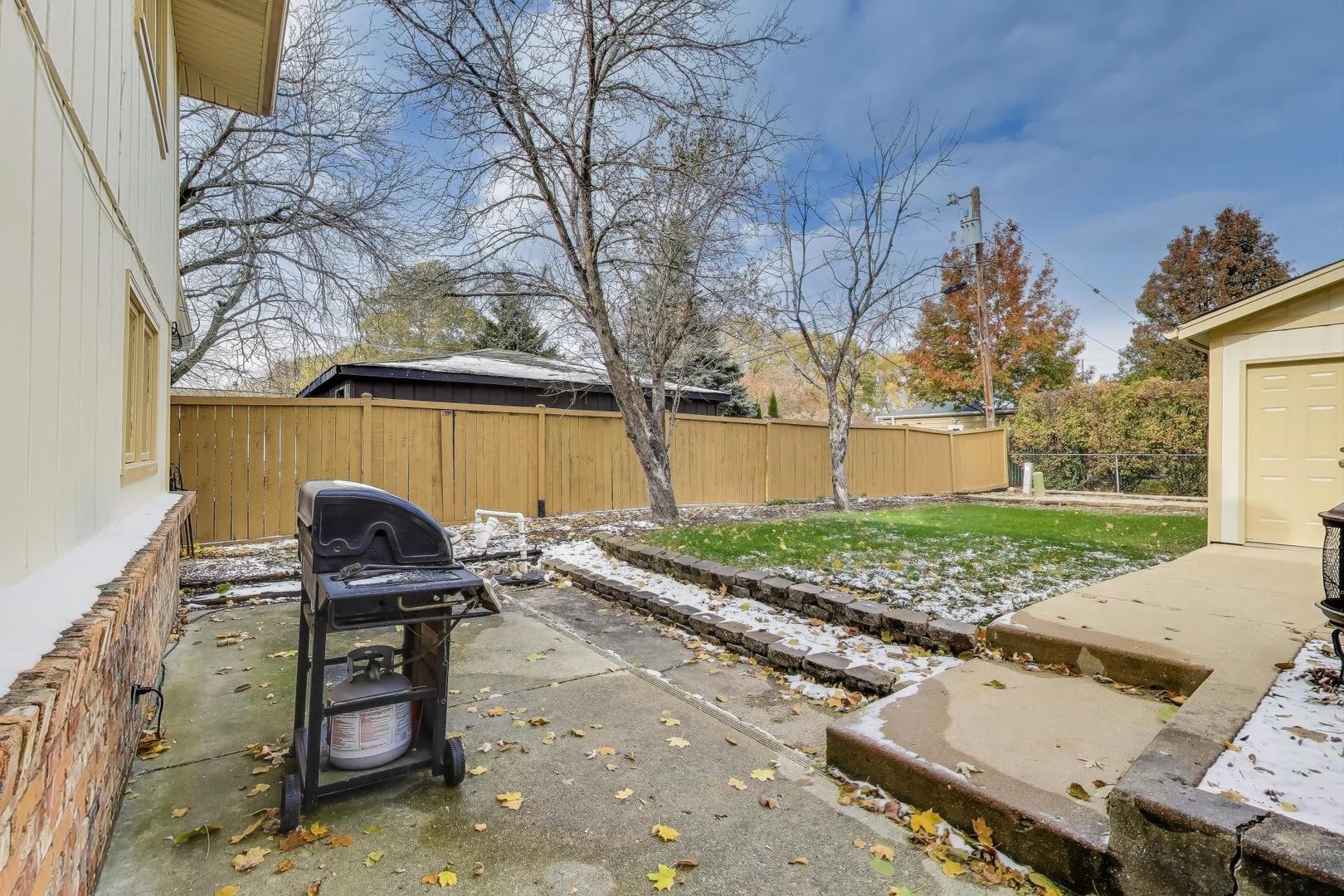 1407 Wilson Avenue Wheaton, IL 60189 - Photo 28 of 31 a view of a patio with table and chairs with wooden fence