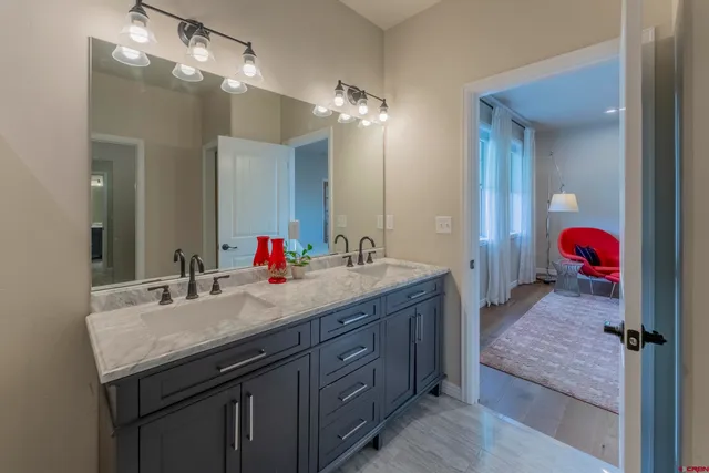 a bathroom with a granite countertop sink a large mirror and shower