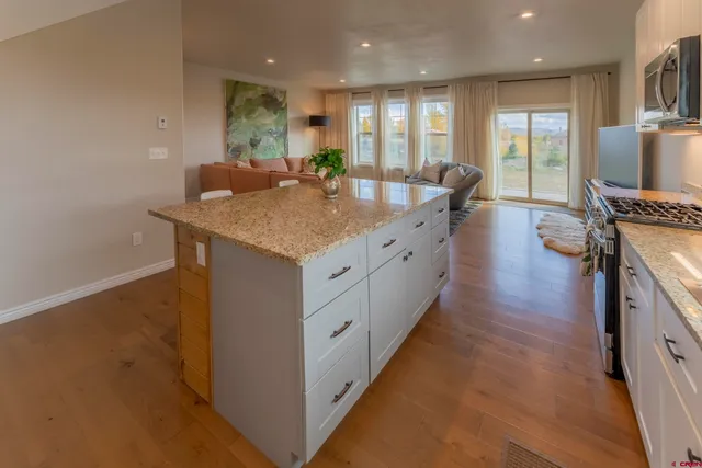 a kitchen with stainless steel appliances a stove a sink refrigerator and microwave