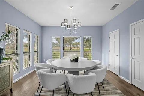 a dining room with furniture a chandelier and wooden floor