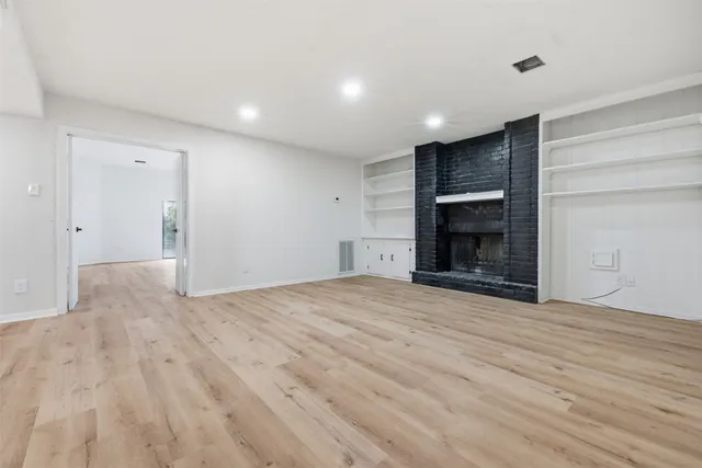 a view of empty room with a fireplace and cabinet