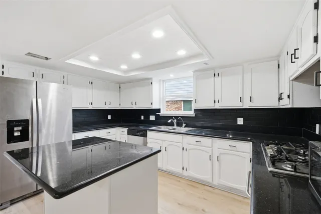 a kitchen with stainless steel appliances a sink a stove a microwave and cabinets