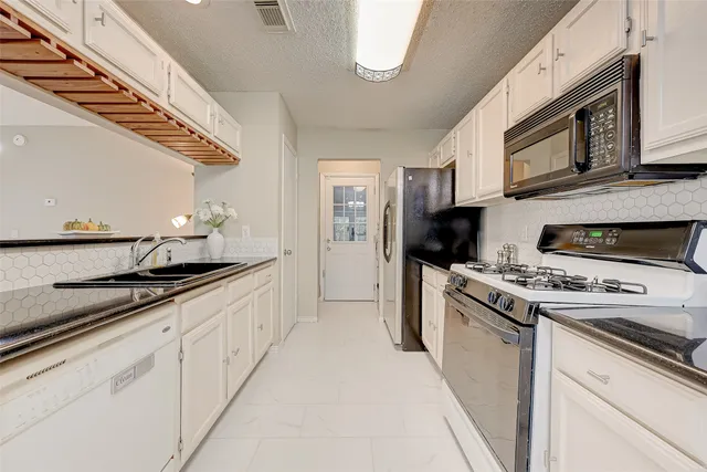 a kitchen with stainless steel appliances granite countertop a sink and a stove
