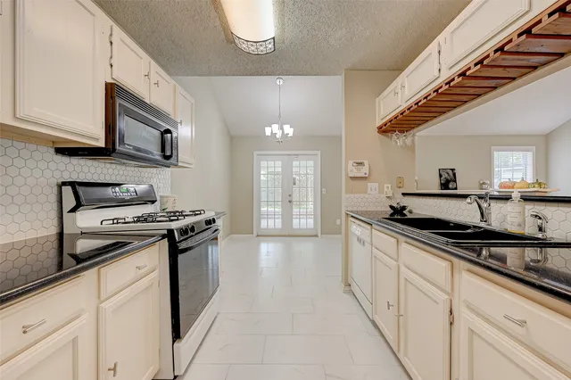 a kitchen with stainless steel appliances granite countertop a sink and a stove