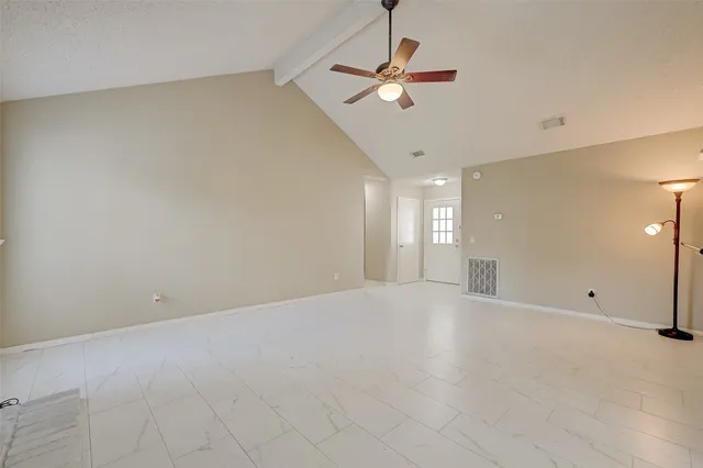 a view of an empty room with a chandelier fan