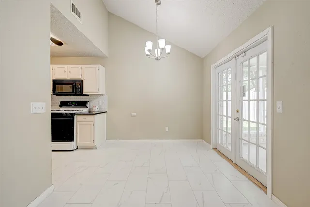a kitchen with granite countertop a stove a sink and a microwave