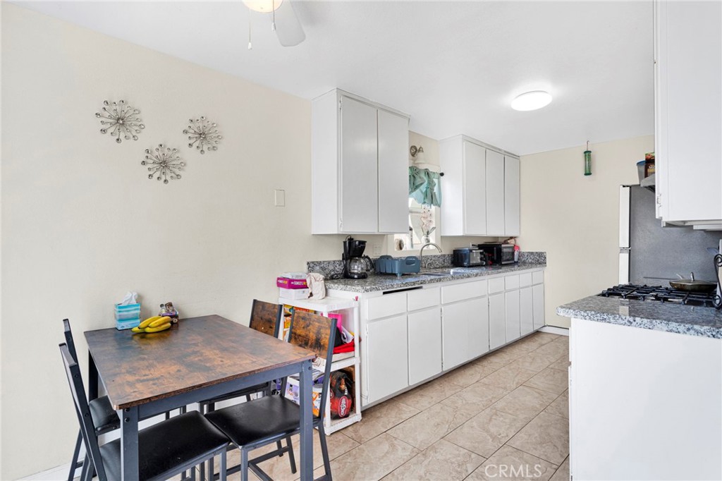 18350 Jonathan Street Adelanto, CA 92301 - Photo 11 of 32 a kitchen with a white cabinets and chairs