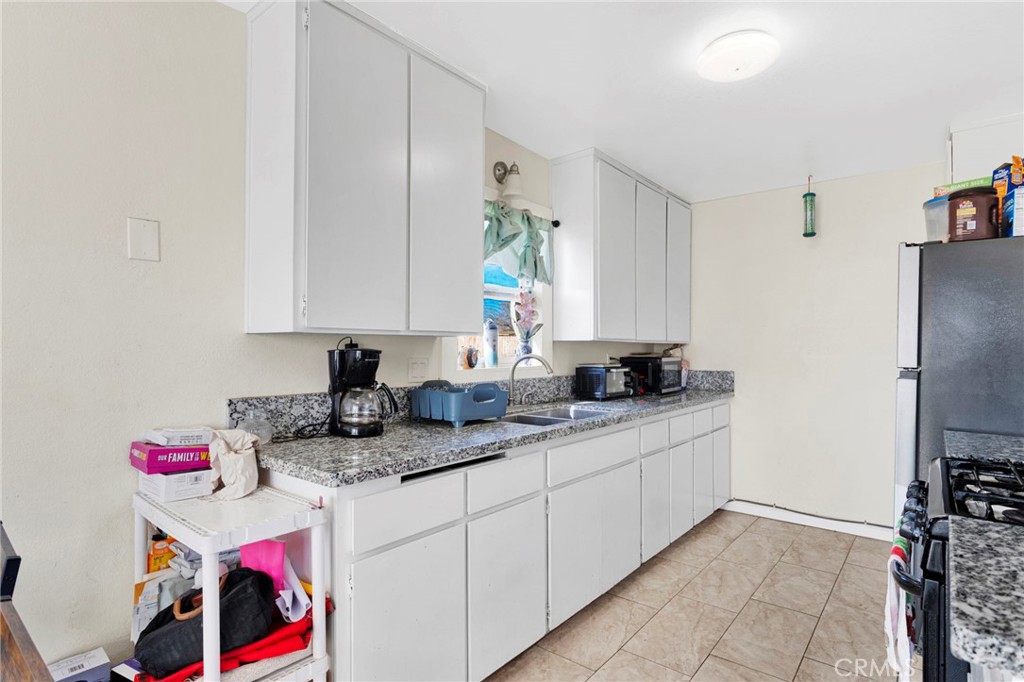 18350 Jonathan Street Adelanto, CA 92301 - Photo 12 of 32 a kitchen with stainless steel appliances granite countertop a sink dishwasher and cabinets with wooden floor