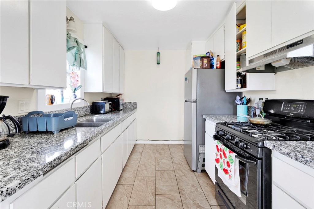 18350 Jonathan Street Adelanto, CA 92301 - Photo 13 of 32 a kitchen with stainless steel appliances granite countertop a stove and a sink