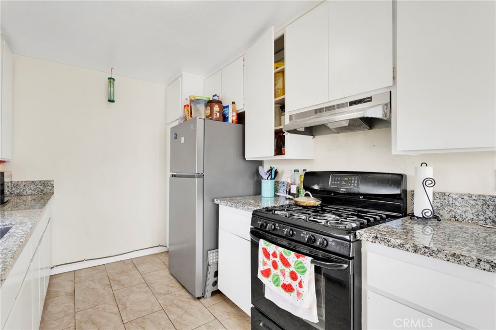 18350 Jonathan Street Adelanto, CA 92301 - Photo 14 of 32 a kitchen with stainless steel appliances granite countertop a stove and a refrigerator