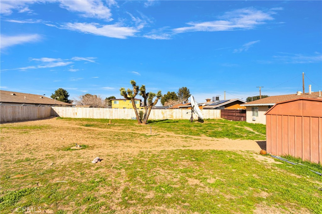 18350 Jonathan Street Adelanto, CA 92301 - Photo 29 of 32 a view of a backyard of a house with a yard
