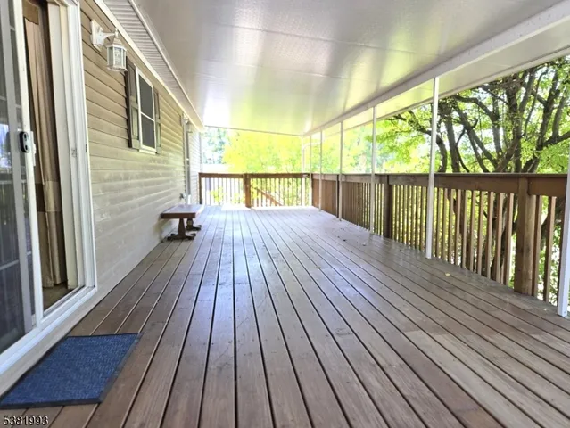 an empty room with a chandelier fan and windows